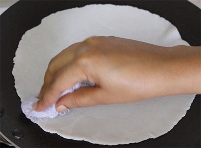 rolled ukkarisida akki rotti or plain rice flour roti on hot pan