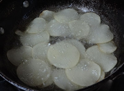 slicing raw potato for potato chips or alugadde chips