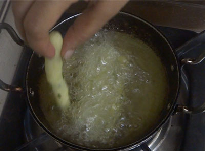 frying aloo rava fingers or potato sooji snacks