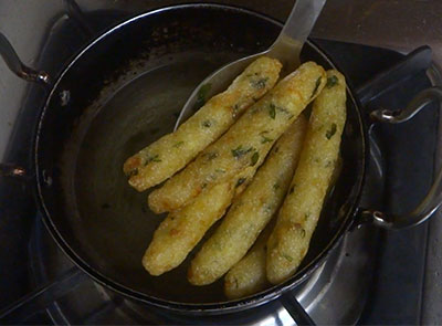 frying aloo rava fingers or potato sooji snacks