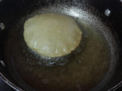 deep frying the pooris for mixed flour poori or hittina vade