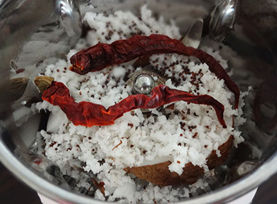 grind coconut and red chili for kadle usli or chana sundal