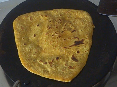 flipping and cooking masala chapati or khara chapathi