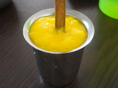 pour mango puree into cup for mango popsicles