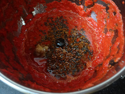 grinding ranjaka or red chili chutney