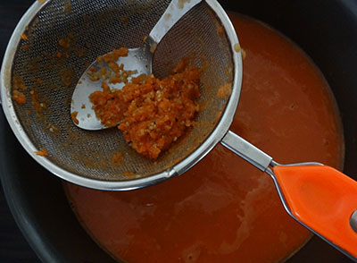 straining the ground tomato for tomato soup