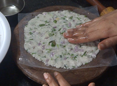 patting akki rotti on the pan