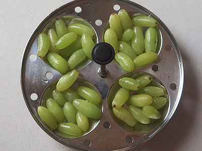 rinsed grapes on a idli plate for home made raisins or dry grapes